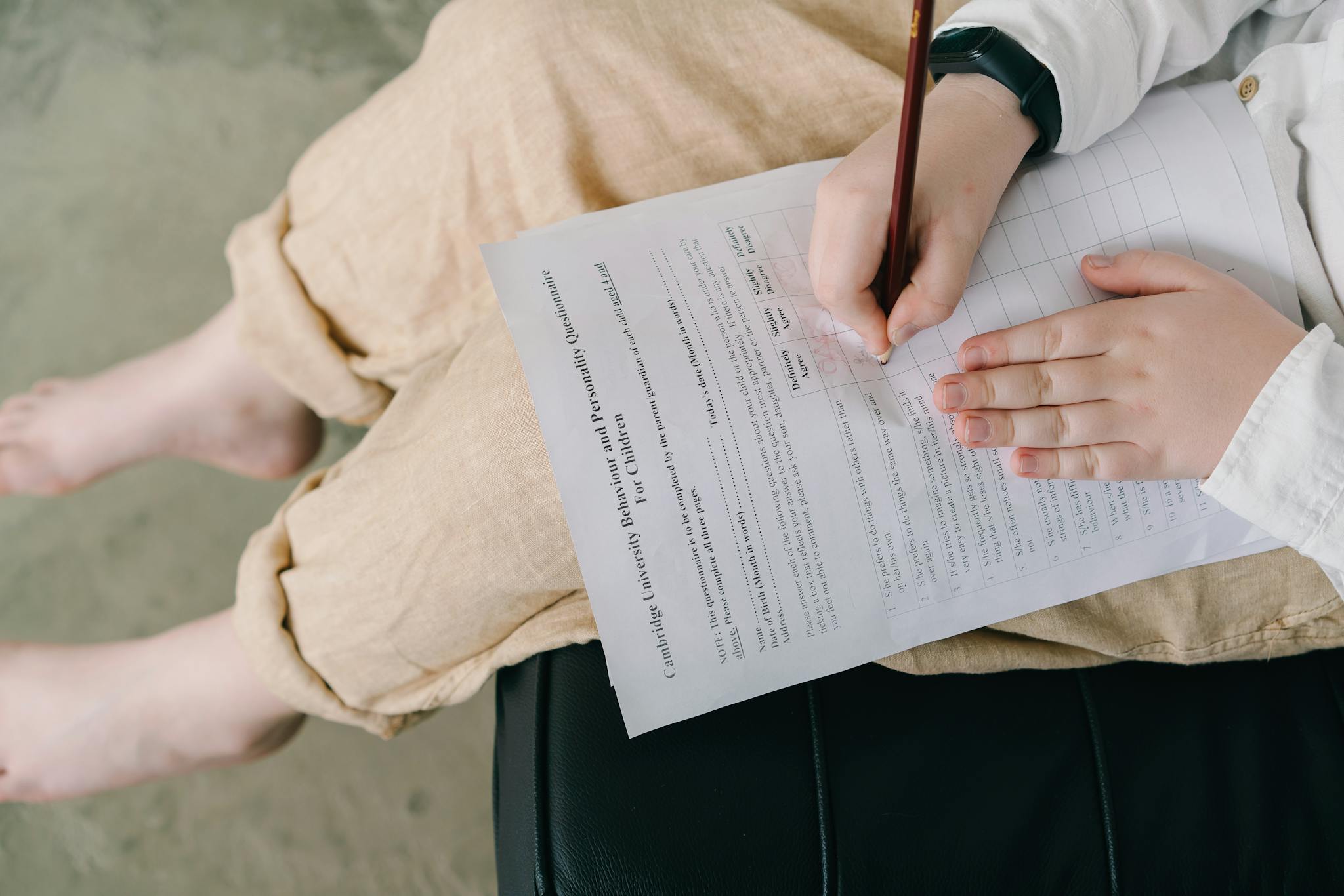 Young child completing a questionnaire indoors for educational purposes.